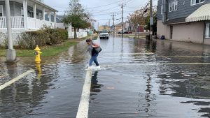 Woman walking through flood waters to cross street